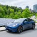 Electric vehicle next to a rooftop solar installation with nearby forest greenery, representing climate change mitigation through clean energy, low-emission transport, and carbon-storing forests.